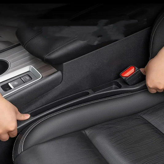 Black car seat gap organizer being fitted between the seat and center console